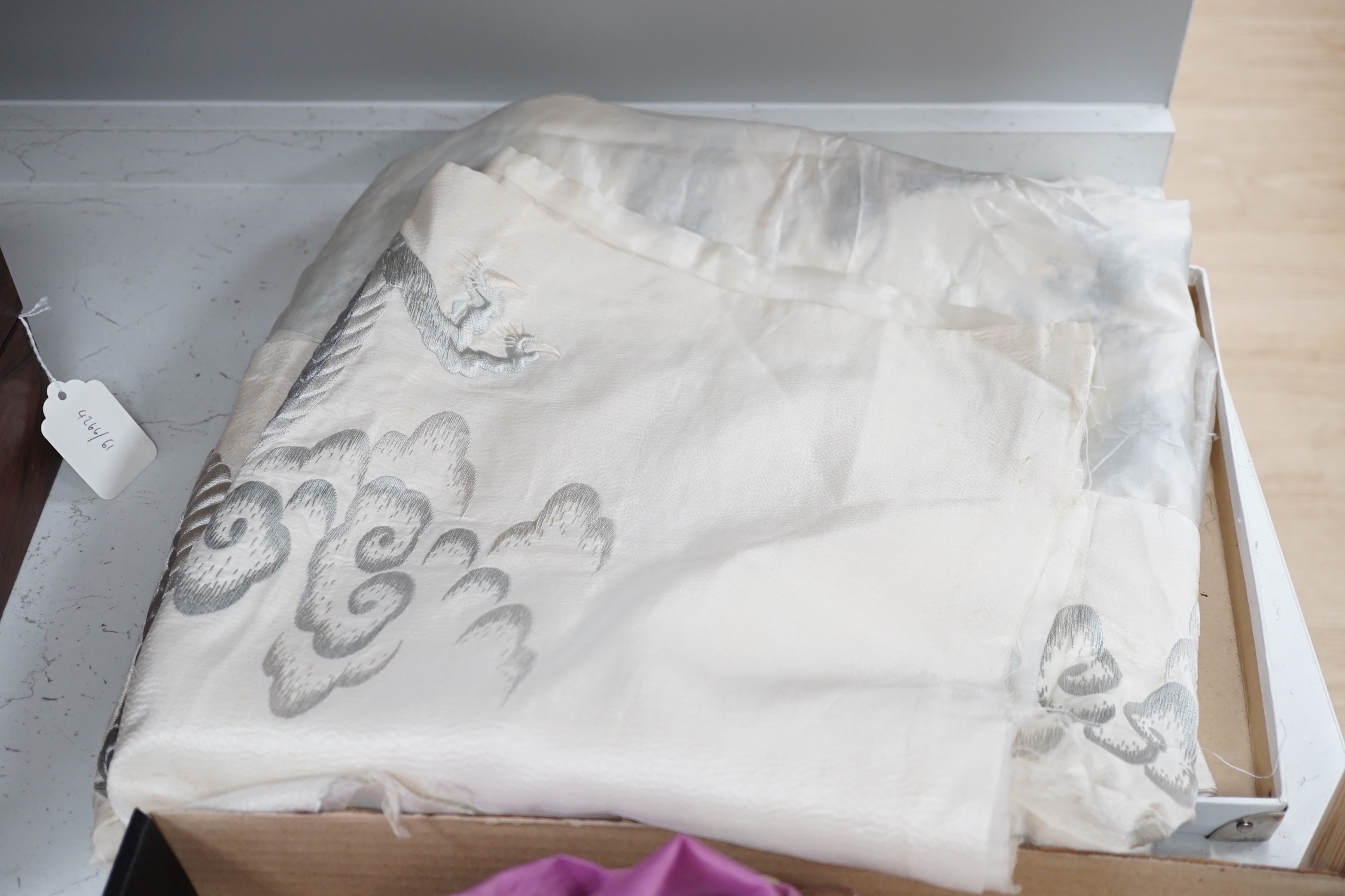 A Japanese silk kimono embroidered on mauve silk with multi-coloured butterflies and flowers, together with a cream silk unmade up kimono richly embroidered with a dragon design